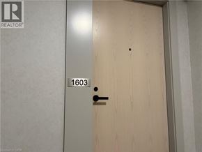 Vaughan condo for rent - A wooden door with a black handle and a number 1603 on the wall.