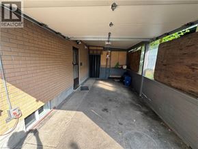 Kitchener apartment for rent - A room with a brick wall and a door leading to a backyard.