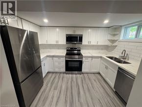 Kitchener apartment for rent - A modern kitchen with stainless steel appliances and white cabinets.
