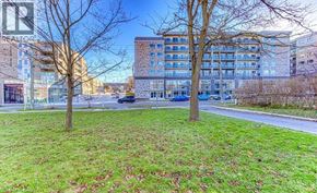 Waterloo condo for rent - A grassy area with trees and a building in the background.