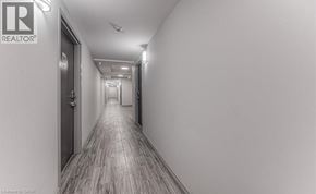 Waterloo condo for rent - A long hallway with a REALTOR sign on the wall.