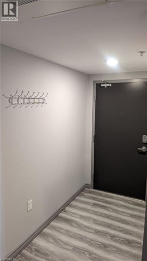 Waterloo condo for rent - A hallway with a black door and a light switch on the wall.