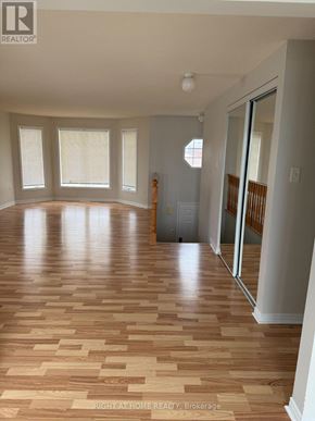 Barrie (Georgian Drive) apartment for rent - A room with wooden flooring and a door on the right side.