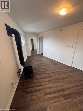 Kitchener apartment for rent - A room with a brown carpet and a black object on the floor.