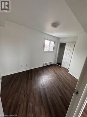 Kitchener apartment for rent - A room with wood flooring and a door on the right.