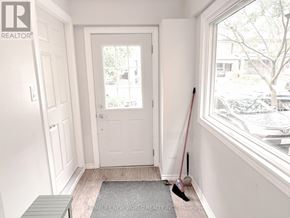 Toronto (High Park-Swansea) apartment for rent - A brokerage sign is on the wall of a white hallway.