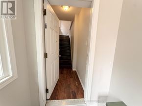 Toronto (High Park-Swansea) apartment for rent - A hallway with a wooden floor and white walls.