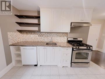 Toronto (High Park-Swansea) apartment for rent - A kitchen with white cabinets and a granite countertop.