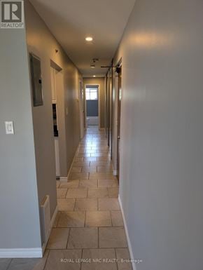 Thorold (Thorold Downtown) multi-family for rent - A long hallway with tiled floors and white walls.