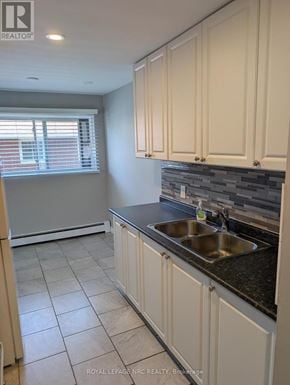 Thorold (Thorold Downtown) multi-family for rent - A kitchen with white cabinets and a black countertop.