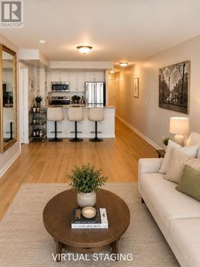 Toronto (Waterfront Communities) condo for rent - A living room with a couch, a coffee table, and a bar area in the background.