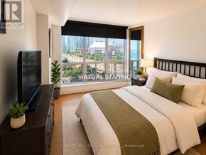 Toronto (Waterfront Communities) condo for rent - A bedroom with a large bed and a flat screen TV.