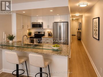 Toronto (Waterfront Communities) condo for rent - A kitchen with a glass counter top and white bar stools.