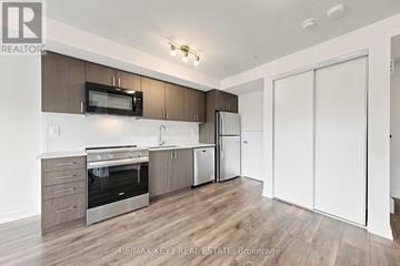 Toronto (Victoria Village) townhouse for rent - A kitchen with brown cabinets and a stainless steel refrigerator.