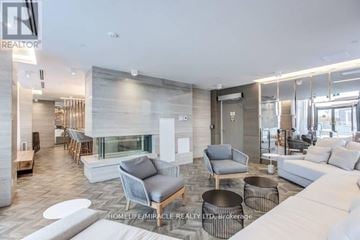 Toronto (Bayview Village) condo for rent - A living room with a white couch and a grey chair.