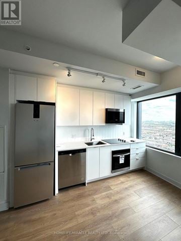 Vaughan (Concord) condo for rent - A modern kitchen with white cabinets and stainless steel appliances.