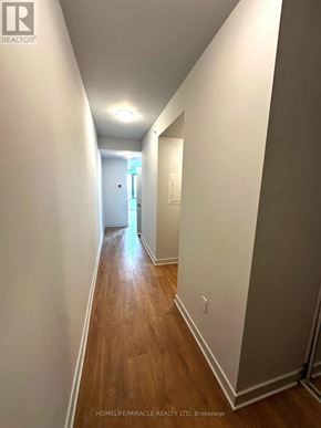 Vaughan (Concord) condo for rent - A long hallway with wood floors and white walls.