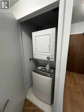 Vaughan (Concord) condo for rent - A small white washing machine is built into a wall.