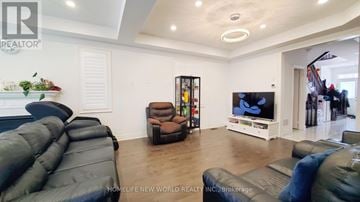 Whitchurch-Stouffville (Stouffville) apartment for rent - A living room with a black leather couch and a flat screen TV.