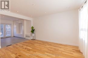 Toronto (Stonegate-Queensway) apartment for rent - A room with wooden flooring and white walls, with a plant on a stand in the corner.
