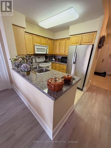 Toronto (Willowdale East) condo for rent - A kitchen with wooden cabinets and granite countertops.