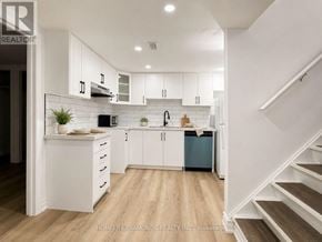 Welland (Prince Charles) apartment for rent - A modern kitchen with white cabinets and a wooden floor.