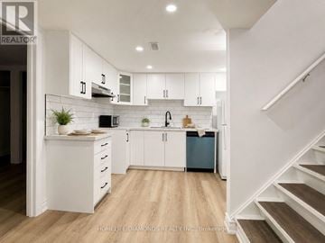 Welland (Prince Charles) apartment for rent - A modern kitchen with white cabinets and a wooden floor.