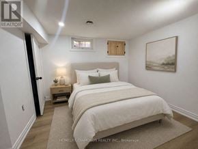 Welland (Prince Charles) apartment for rent - A bedroom with a large bed and a painting on the wall.