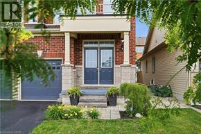 Niagara-On-The-Lake apartment for rent - A house with a blue door and a window is surrounded by greenery.