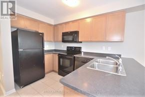 Milton (Sc Scott) townhouse for rent - A kitchen with black appliances and wooden cabinets.