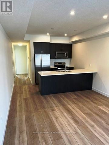 Cambridge townhouse for rent - A kitchen with black cabinets and a wooden floor.
