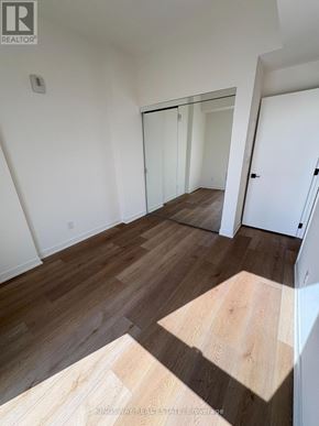 Brantford condo for rent - A room with wooden flooring and white walls.