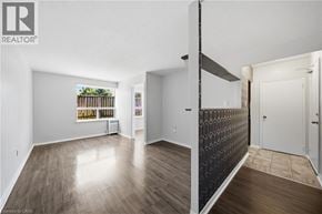 Scarborough apartment for rent - A room with wooden floors and white walls, with a window showing a fence and trees.