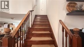 Hamilton apartment for rent - A wooden staircase with a carpeted runner leads up to a white door.