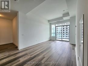 Pickering (Bay Ridges) condo for rent - A spacious room with wood flooring and a large window.