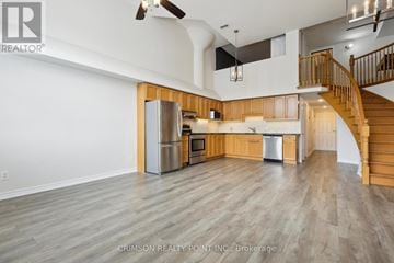 Brantford townhouse for rent - A spacious kitchen with wooden cabinets and a stainless steel refrigerator.