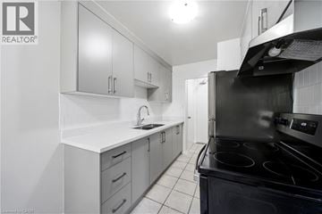 Scarborough apartment for rent - A modern kitchen with white cabinets and black appliances.