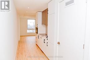 Kitchener condo for rent - A white kitchen with wooden floors and white walls.