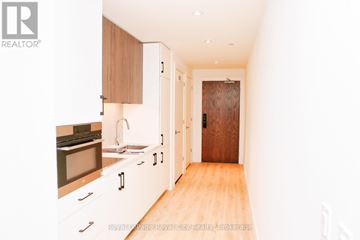 Kitchener condo for rent - A kitchen with wooden cabinets and a sink.