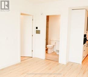 Kitchener condo for rent - A white bathroom with a toilet and a wooden floor.