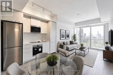 Toronto (Regent Park) condo for rent - A modern kitchen with a glass table and a view of the city.