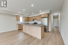 Toronto (Downsview-Roding-Cfb) multi-family for rent - A spacious kitchen with wooden floors and cabinets.