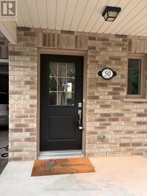 St. Catharines (Secord Woods) townhouse for rent - A brown door with a glass window and a welcome mat in front.
