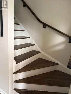 St. Catharines (Secord Woods) townhouse for rent - A staircase with wooden steps and a dark brown handrail.