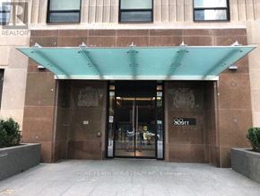 Toronto (Church-Yonge Corridor) condo for rent - The entrance to a building with a glass door and a green awning.