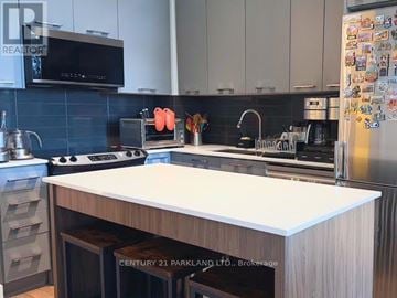 Richmond Hill (Observatory) condo for rent - A kitchen with a white countertop and a refrigerator covered in magnets.
