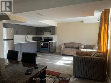 Cambridge apartment for rent - A kitchen area with a refrigerator, microwave, oven, and a table with chairs.