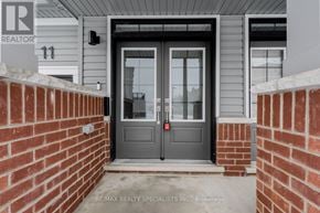 Cambridge townhouse for rent - A grey door with a glass window and a black handle is the main focus of the image.