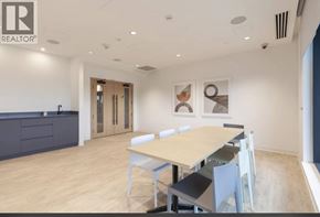 Burnaby apartment for rent - A conference room with a table and chairs and a logo on the wall.