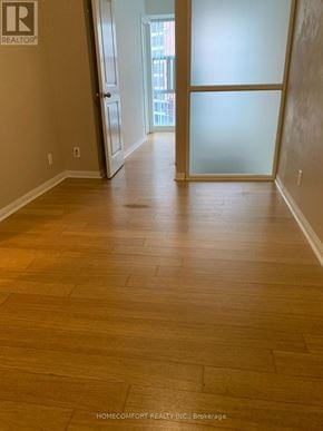 Toronto (Bay Street Corridor) house for rent - A room with wooden flooring and a glass door leading to a balcony.